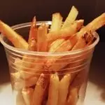 Homemade French Fries in a clear plastic cup.