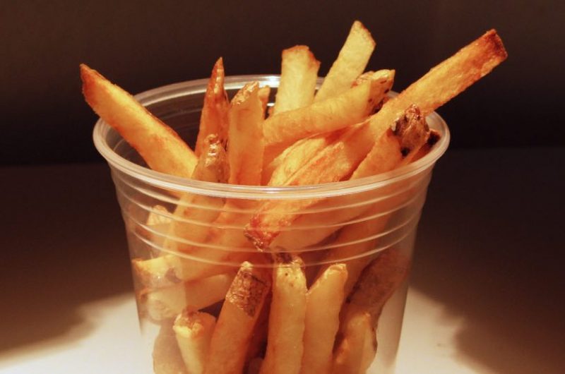 Homemade French Fries in a clear plastic cup.