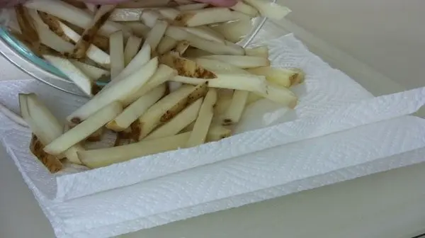 Several fry shaped potatoes drying on a paper towel Several fry shaped potatoes drying on a paper towel