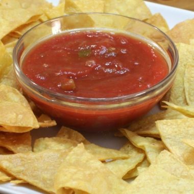 homemade tortilla chips on a white plate with salsa