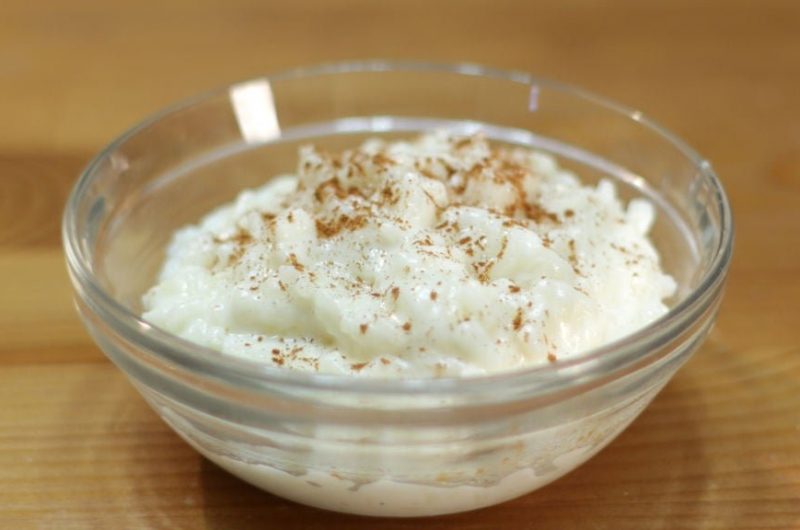 Glass bowl of rice pudding topped with cinnamon