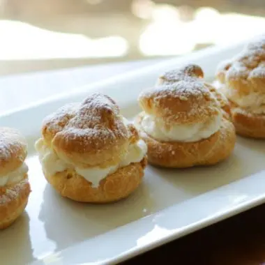 Easy homemade cream puffs sitting on a white plate