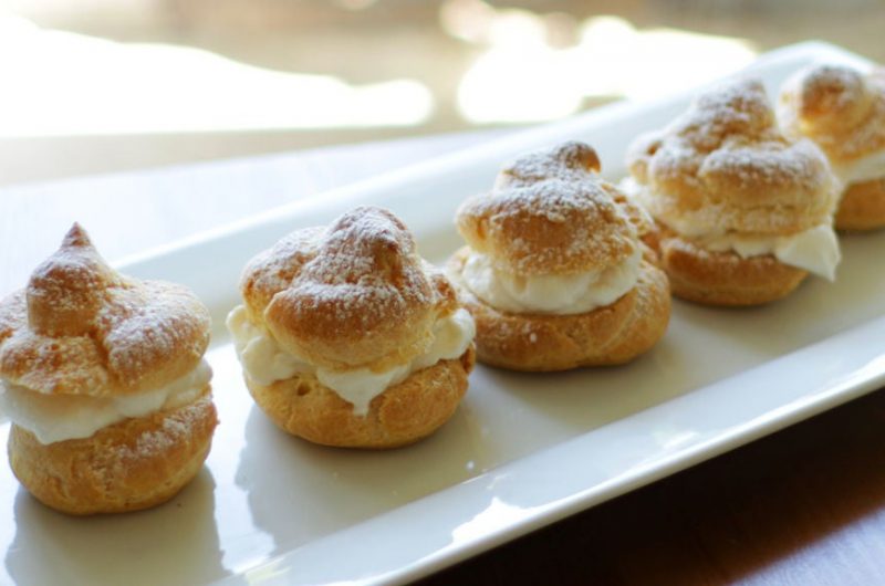 Easy homemade cream puffs sitting on a white plate