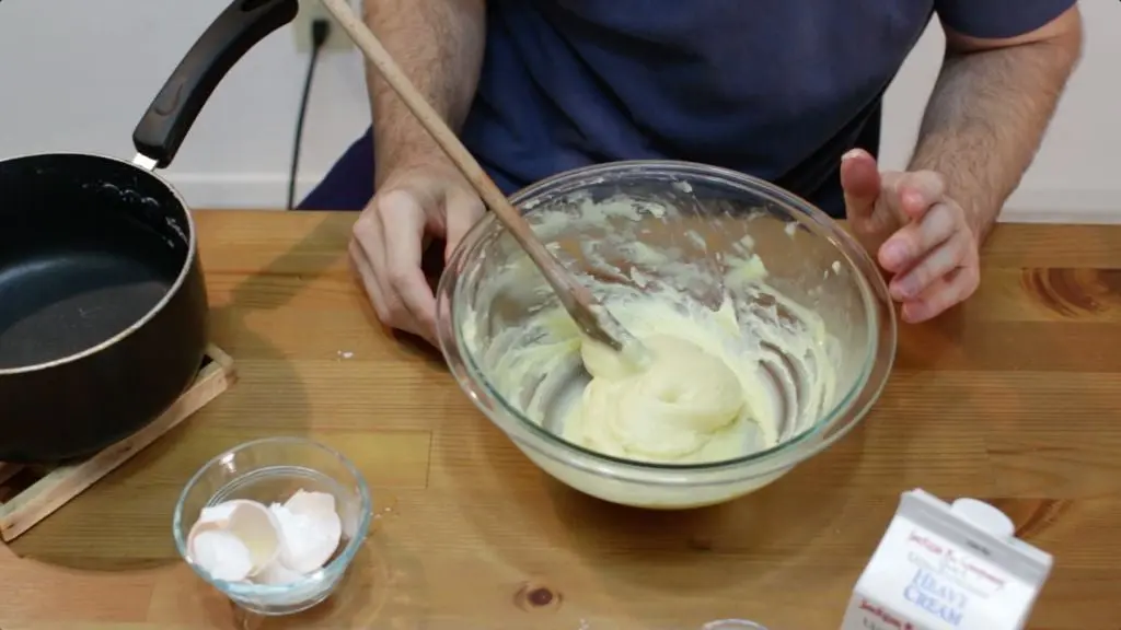 Finished homemade cream puffs dough in a large glass bowl on top of a table