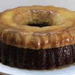 Chocoflan recipe cake on a white cake pedestal on wooden table