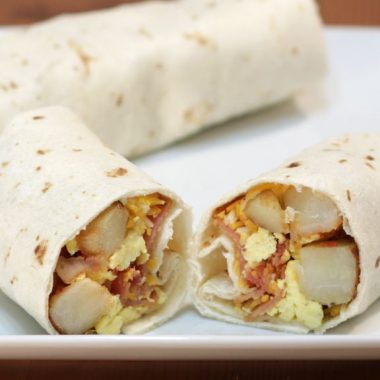 easy breakfast burrito cut in half on a white plate
