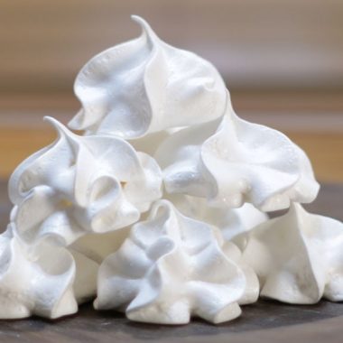 stack of easy meringue cookies on a wooden plate