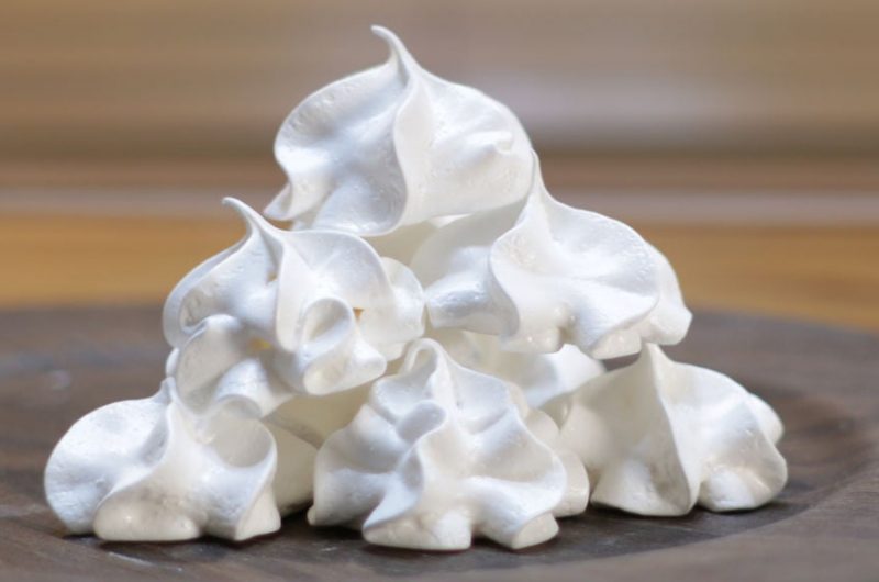 stack of easy meringue cookies on a wooden plate