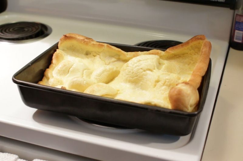 German pancakes in a 13x9 pan on a stovetop
