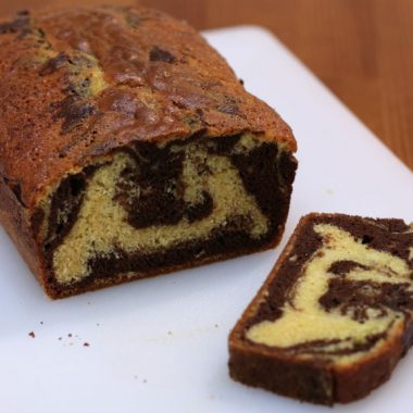 Marble cake sliced on a white cutting board