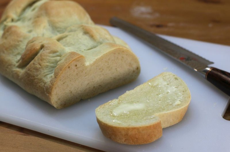 easy basic Italian bread sitting on a white cutting board next to a knife