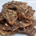 homemade almond roca piled up on a white plate