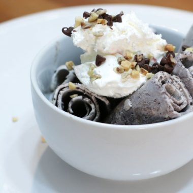 ice cream rolls in a bowl on a white cake pedestal