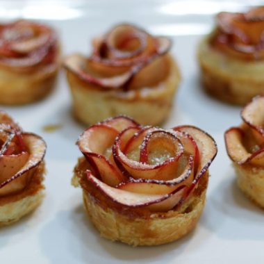 apple roses on a white plate on a wooden table