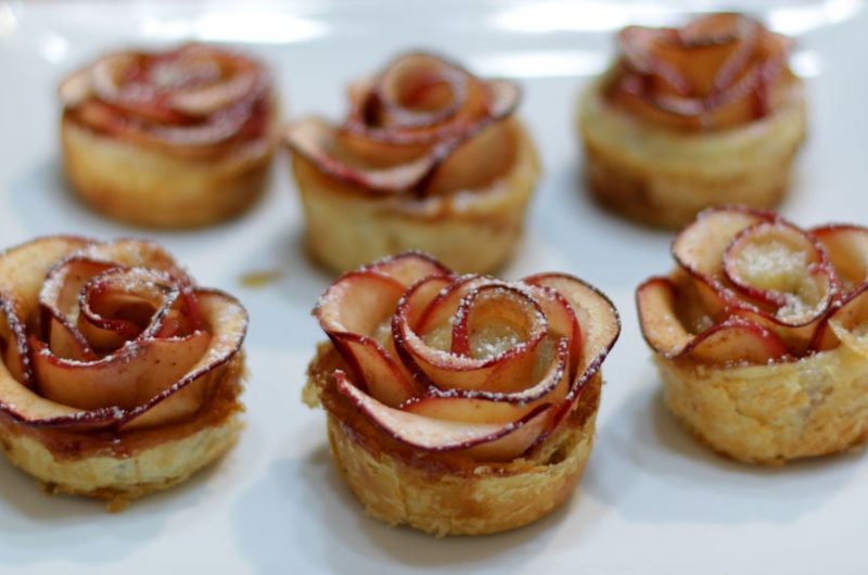apple roses on a white plate on a wooden table