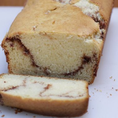 cinnamon quick bread sliced on a white cutting board