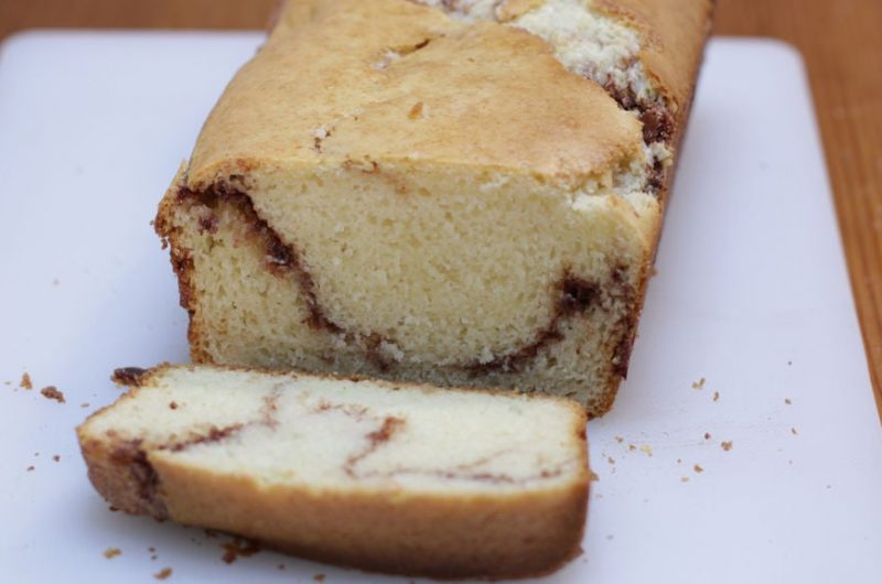 cinnamon quick bread sliced on a white cutting board