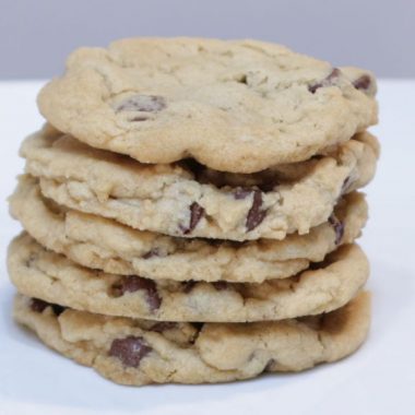 5 stacked eggless chocolate chip cookies on a white plate