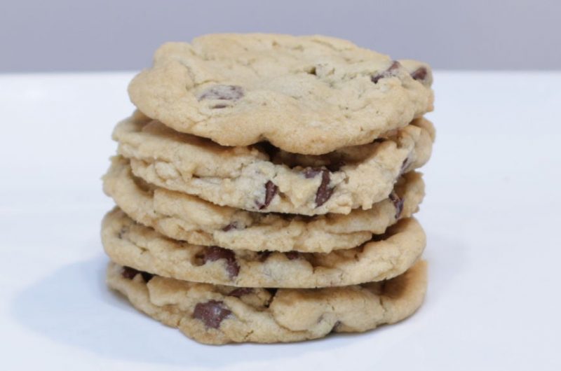 5 stacked eggless chocolate chip cookies on a white plate