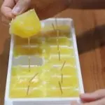 ice cube tray popsicles with toothpicks on top of wooden table