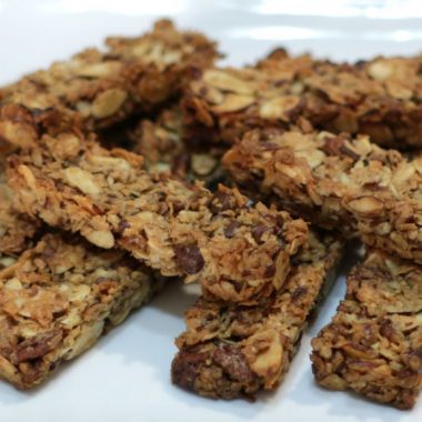 Keto granola bars piled up on a white plate