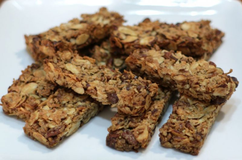 Keto granola bars piled up on a white plate