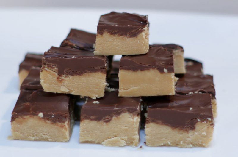 Homemade peanut butter cup fudge on a white plate on a table