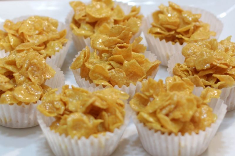 Star shaped honey coated cereal in a white bowl and wooden