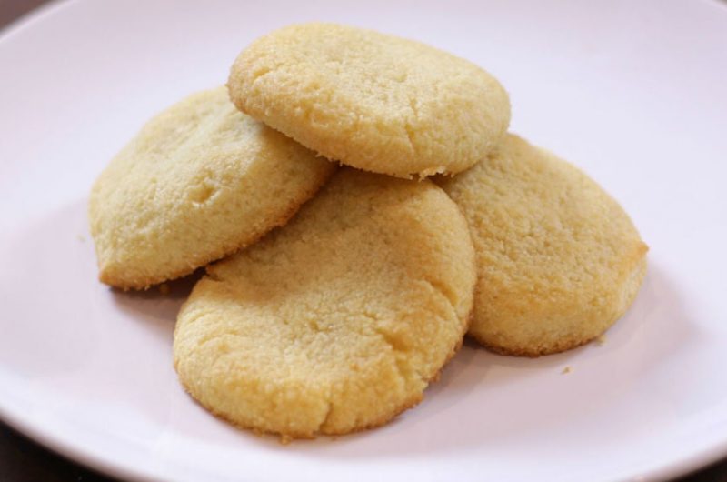 Keto shortbread cookies piled on a white plate.