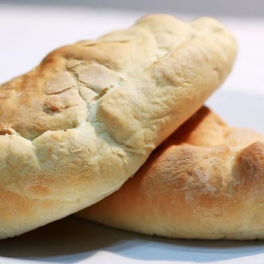 easy calzones piled on a white plate on a table.