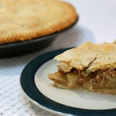 slice of easy apple pie next to another pie.
