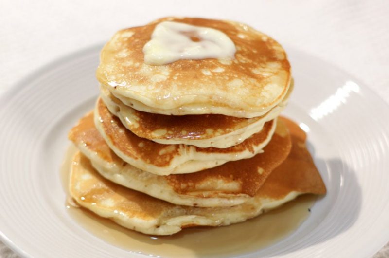 Stack of easy fluffy pancakes on a white plate