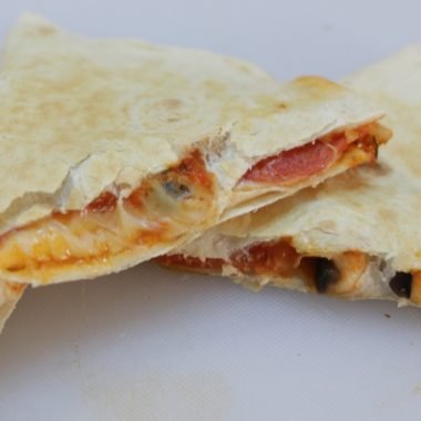 Easy homemade pizza quesadillas piled on a white cutting board