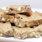 Homemade blondies pile on a white plate