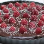 Chocolate raspberry tart on a white table
