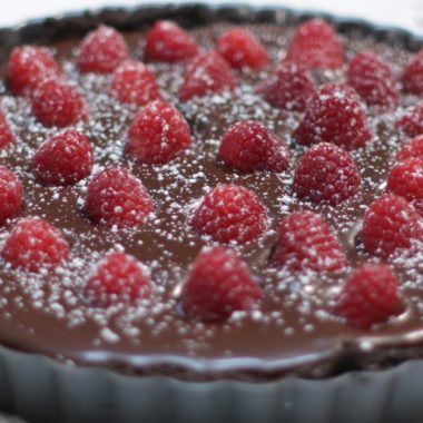 Chocolate raspberry tart on a white table