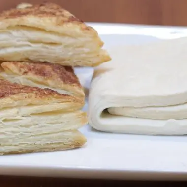 Homemade puff pastry dough folded next to cinnamon tarts