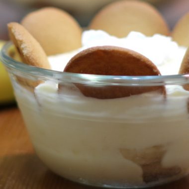 banana pudding in a small glass bowl on a wooden table