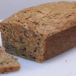 Sliced zucchini bread on a white cutting board.