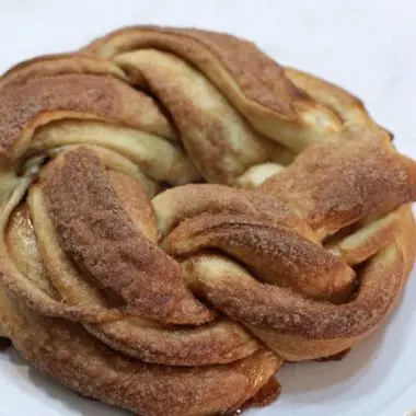 Cinnamon roll twist bread on a cake pedestal