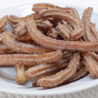 White round plate full of homemade churros