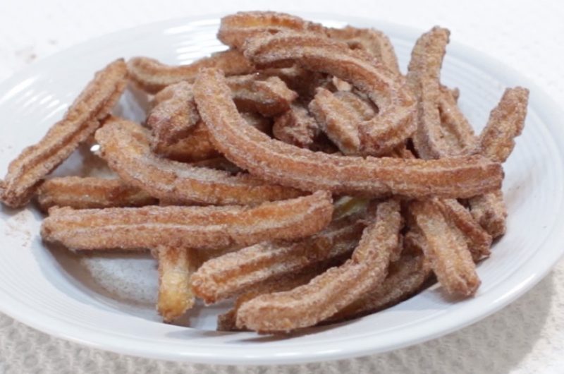 White round plate full of homemade churros