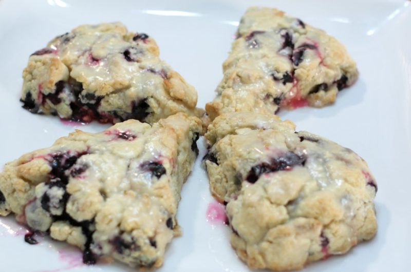 Four blueberry scones on a white plate