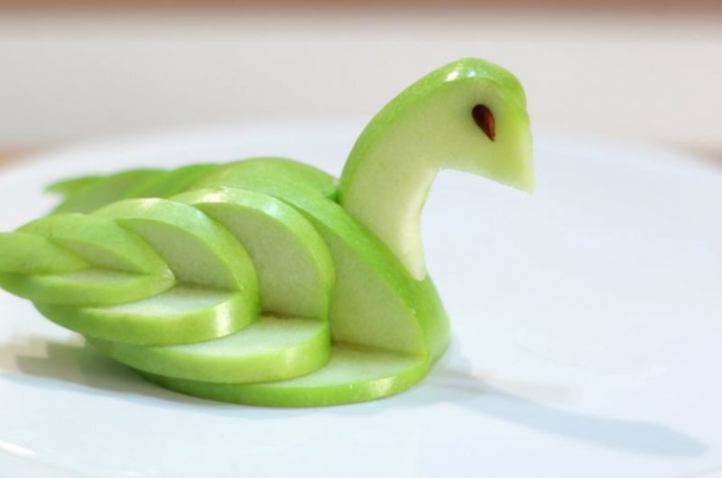 edible apple swan on a white cake pedestal
