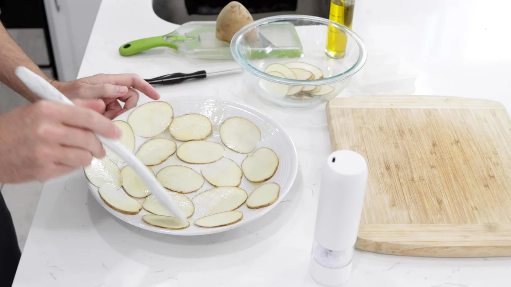 Potato slices arranged in a single layer on a plate. Potato slices arranged in a single layer on a plate.