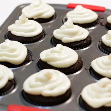Pan full of homemade chocolate cupcakes with cream cheese frosting