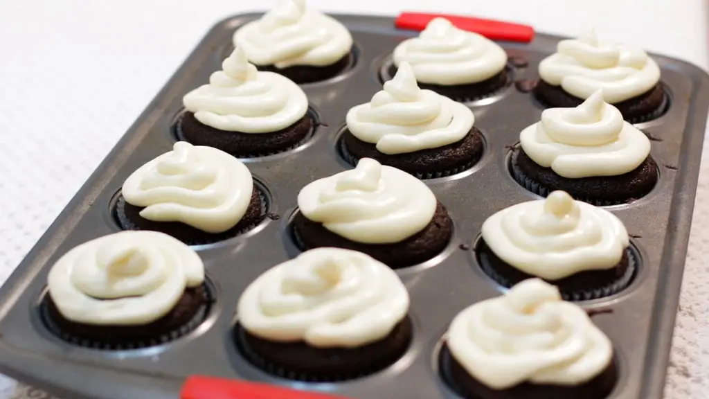 Pan full of homemade chocolate cupcakes with cream cheese frosting