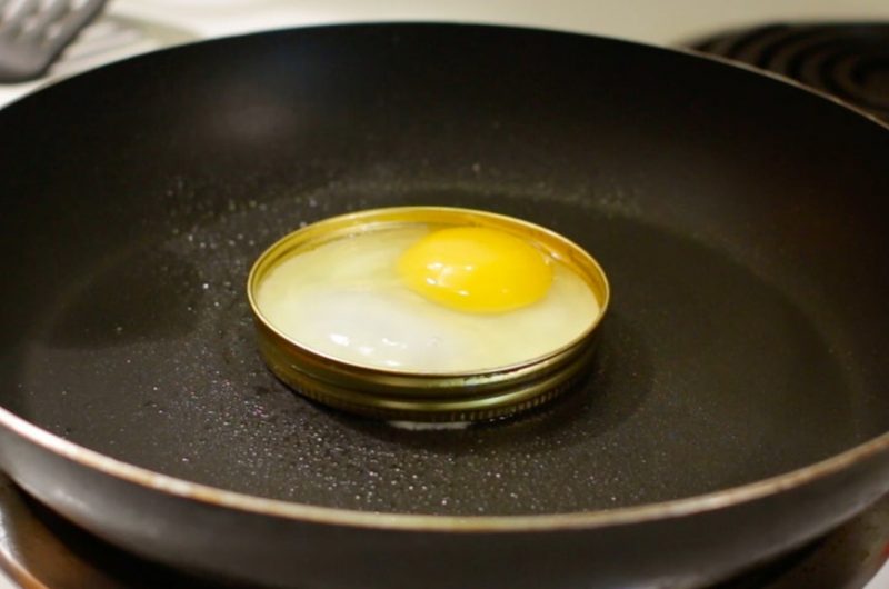 An egg in a mason jar ring in a skillet.