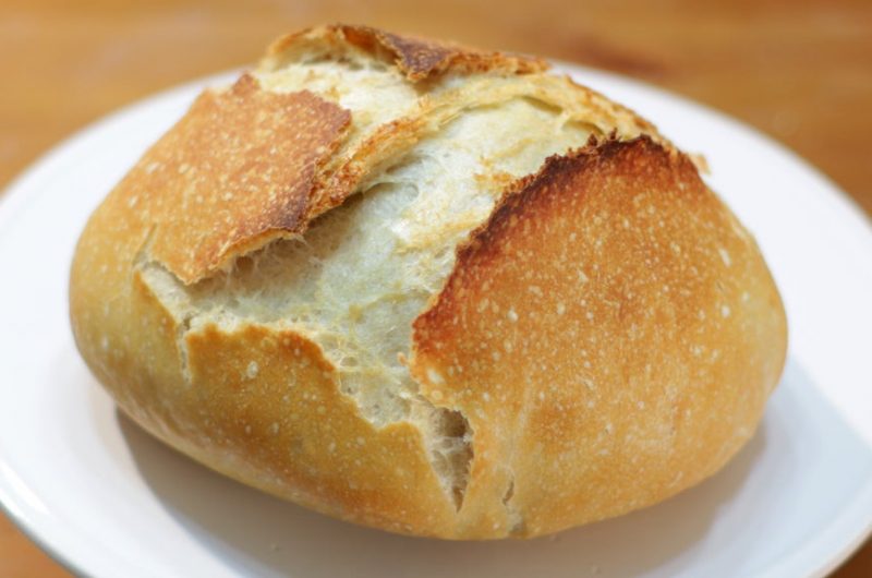No knead bread on a white cake pedestal