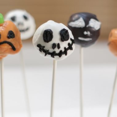 Brownie pops decorated with a Halloween theme on a table.